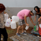 Residents use a water faucet on the side of a building to fill water jugs due to lack of water service following Hurricane Maria